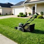 Battery lawn mower on a half-mown front lawn