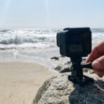 Action camera being mounted on a rock at the edge of a beach