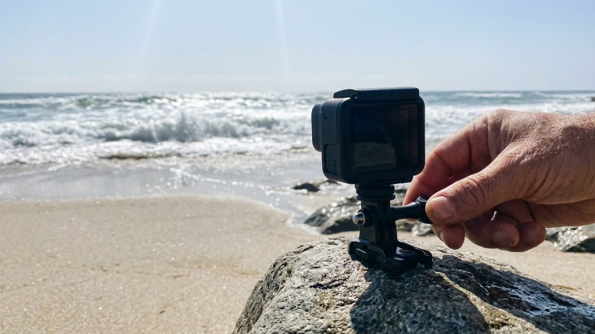 Action camera being mounted on a rock at the edge of a beach