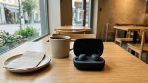 Wireless earbuds in an open charging case on a cafe table