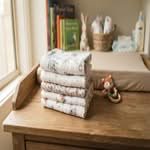 Stack of the best baby burp cloths in Australia, folded and ready for use on a changing table.