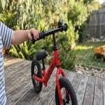 Close-up of a red balance bike, highlighting it as one of the best balance bikes for toddlers in Australia.