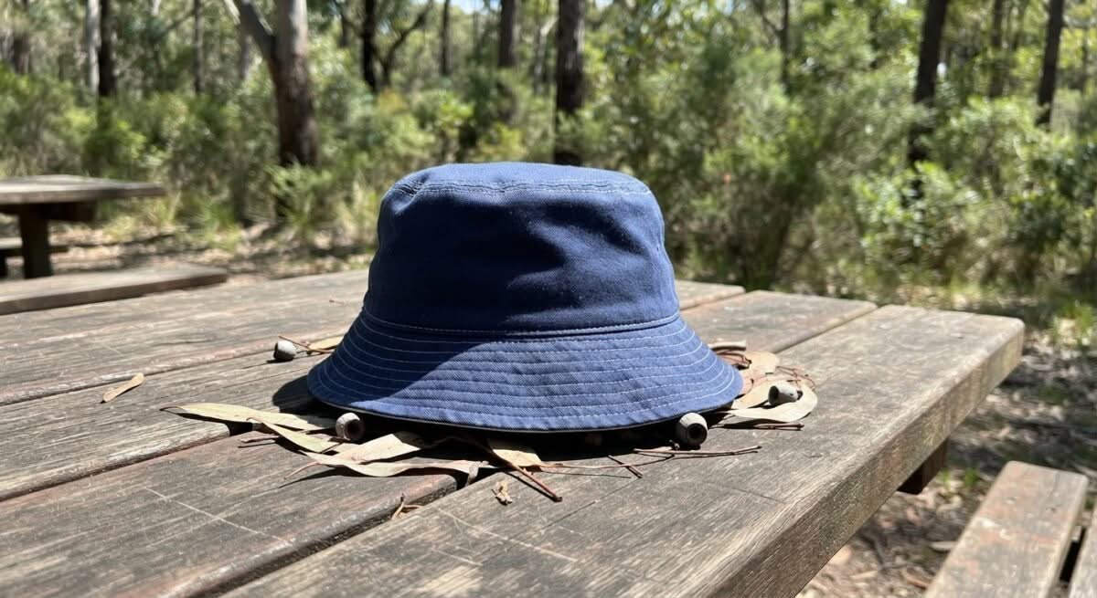 A blue bucket hat, one of the best bucket hats in Australia, shown outdoors.