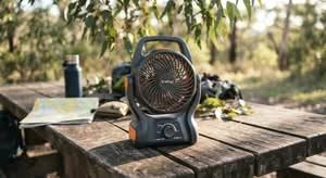 A modern portable camping fan, ideal for Australian conditions, shown on an outdoor picnic table.