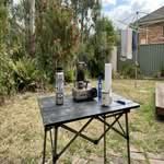 A top-rated camping table for sale in Australia, shown in a realistic outdoor setting.