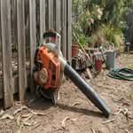 A powerful leaf blower, ideal for Australian conditions, shown in a backyard setting.