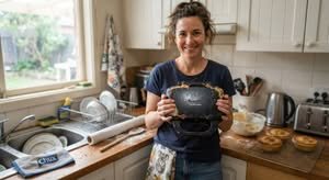A person holding the best pie maker Australia has to offer in a home kitchen.