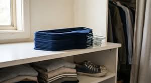 A stack of navy blue velvet clothes hangers, ideal for organizing wardrobes in Australia.