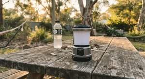 Modern LED camping lantern on a picnic table, representing the best camping lanterns Australia has to offer.