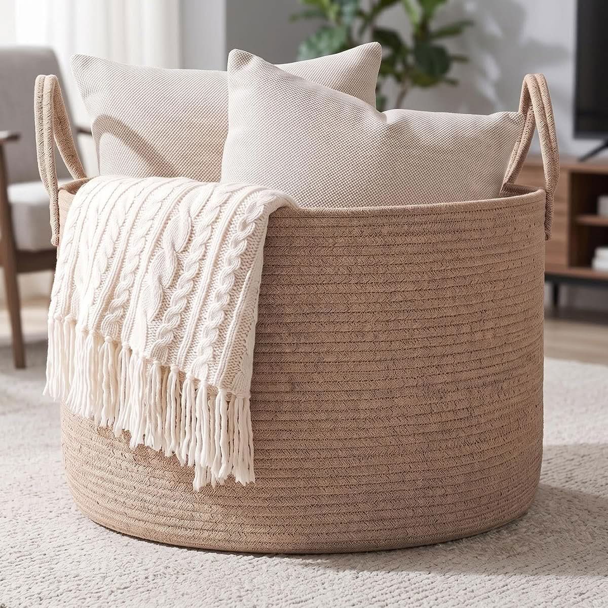 Oatmeal woven rope blanket basket with handles in a bedroom setting