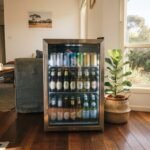 A modern bar fridge filled with drinks in a bright Australian home setting representing the best bar fridge australia options.