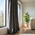 Close up of high quality charcoal blackout curtains hanging in a bright Australian home living room